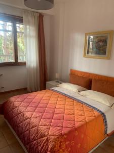 een slaapkamer met een groot bed en een rode deken bij Mostacciano Roma IFO in Rome