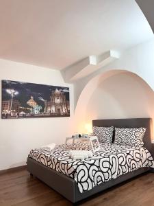 a bedroom with a large bed with a painting on the wall at Casa Vacanza Ti Ospito io in Catania
