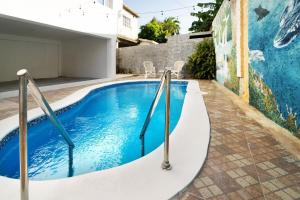 - une piscine en face d'un bâtiment orné d'une fresque murale dans l'établissement Vibrant 1 Bed 1 Bath with Pool, à Las Flores