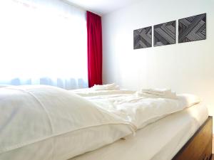 - un lit blanc dans une chambre avec fenêtre dans l'établissement Terminal Design Apartment - Terrasse & waipuTV, à Steinenbronn