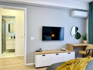 een slaapkamer met een tv aan een witte muur bij City Center Apartment With Balcony in Timişoara