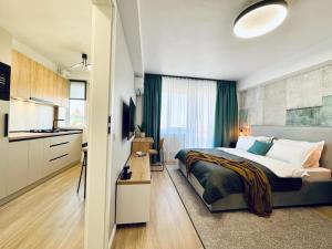 a bedroom with a large bed and a kitchen at City Center Apartment With Balcony in Timişoara