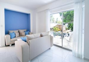 a living room with a white couch and a large window at Stylish 2 bed 1 bath Sleeps 4 in Las Flores