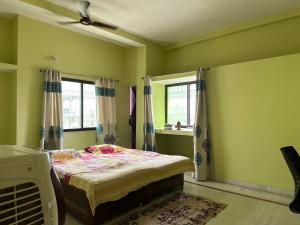 um quarto com uma cama e duas janelas em Amma’s Om stay em Patna