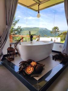 ein Bad mit einer weißen Badewanne und einem Fenster in der Unterkunft ALTITUDE MÁXIMA - Cabanas de Altitude in Urubici