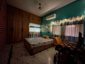 1 dormitorio con cama y pared verde en Amma’s Om stay, en Patna