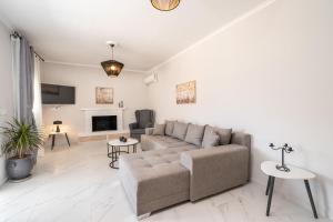 a living room with a couch and a fireplace at Julia's Home in Karavomylos