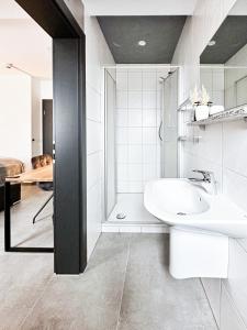 uma casa de banho branca com um lavatório e um chuveiro em Si-View Doppelzimmer Zimmer 10 em Siegen