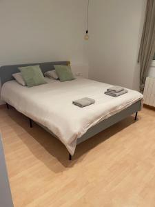 a large bed in a room with a wooden floor at Maison des Hortensias in El Vendrell