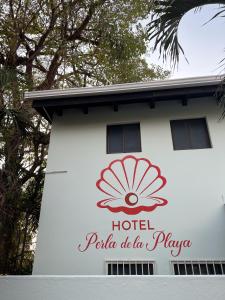 un panneau indiquant un hôtel sur un bâtiment dans l'établissement Hotel Perla de la Playa, à Tamarindo