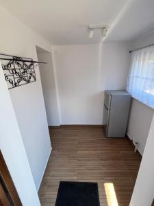a small room with a refrigerator and a window at Apartament ~ Nad Zatoką in Jastarnia