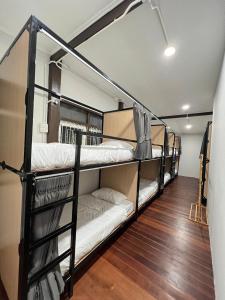 two bunk beds in a room with wood floors at House Ju in Bangkok