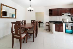 uma cozinha e sala de jantar com uma mesa de madeira e cadeiras em Inviting 3-Bed 2-Bath em Las Flores