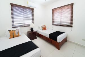 2 Betten in einem Zimmer mit 2 Fenstern in der Unterkunft Inviting 3-Bed 2-Bath in Las Flores
