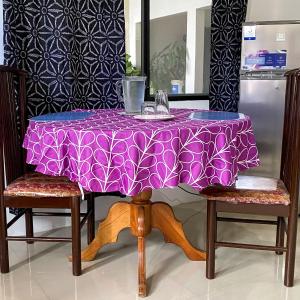 mesa púrpura con 2 sillas y nevera en Suite de Asdruval en Puerto Baquerizo Moreno