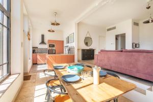 a kitchen and living room with a wooden table and chairs at Family home with garden in Toulon - Welkeys in Toulon