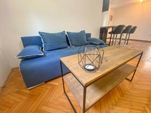 a blue couch in a living room with a table at Cute & Cosy Apartment Emi in Koper