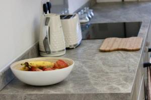 a bowl of fruit on a counter in a kitchen at Modern Guest Lodge, Centrally Located, Free Parking, 8 Min to LGW Airport in Crawley