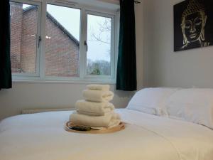 a stack of towels sitting on top of a bed at Modern Apartment, Centrally Located, Free Parking, 8 Min to LGW Airport in Crawley