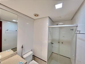 uma casa de banho com um chuveiro e um WC. em Charmoso apartamento no Jardim Goiás em Goiânia