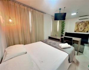 um quarto com uma cama e uma secretária com uma pintura de leão em Charmoso apartamento no Jardim Goiás em Goiânia