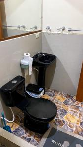 a bathroom with a black toilet and a mirror at Suite de Asdruval in Puerto Baquerizo Moreno