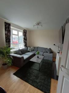 uma sala de estar com um sofá e uma mesa em Spacious 3 bed flat opp Springfield park, Hackney. em Londres