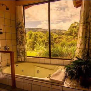 a bath tub in a bathroom with a window at El Toucanet Lodge in El Copey