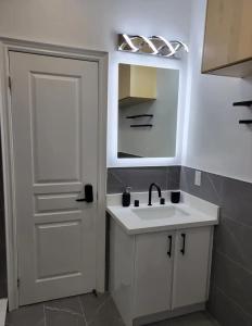 La salle de bains blanche est pourvue d'un lavabo et d'un miroir. dans l'établissement Upscale 2BR Condo - Near Miliken District Park, à Markham