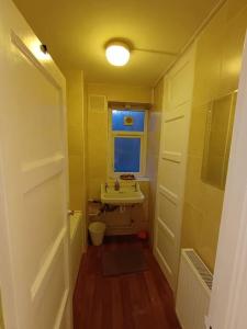 uma pequena casa de banho com um lavatório e uma janela em Spacious 3 bed flat opp Springfield park, Hackney. em Londres
