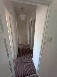 um corredor vazio com uma escada num apartamento em Spacious 3 bed flat opp Springfield park, Hackney. em Londres