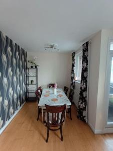 uma sala de jantar com uma mesa e cadeiras num quarto em Spacious 3 bed flat opp Springfield park, Hackney. em Londres