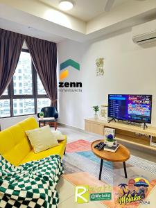 ein Wohnzimmer mit einem gelben Sofa und einem TV in der Unterkunft The Bali Residences Premium Suites Melaka in Malakka