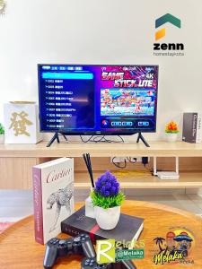 a desk with a tv and a computer monitor on a table at The Bali Residences Premium Suites Melaka in Melaka