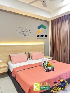 ein Schlafzimmer mit einem Bett mit orangefarbener Bettwäsche und einem Schild in der Unterkunft The Bali Residences Premium Suites Melaka in Malakka