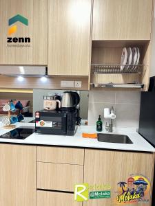 a kitchen with a microwave and a sink at The Bali Residences Premium Suites Melaka in Melaka