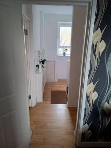 a hallway with a hallway leading to a room at Spacious 3 bed flat opp Springfield park, Hackney. in London