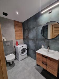 een badkamer met een wasmachine en een wastafel bij Apartament w centrum Radomia in Radom