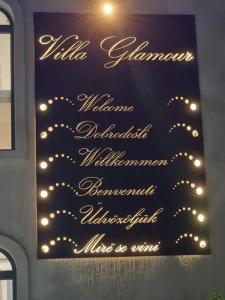 una señal en una pared con luces encendidas en Villa Glamour, en Kruče