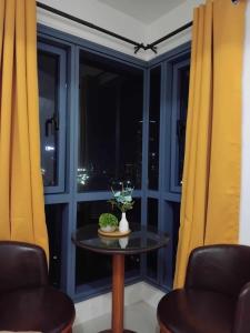 a table in front of a window with yellow curtains at Grand Riviera Suites in Manila
