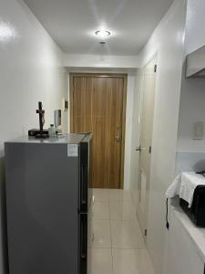 uma cozinha com um frigorífico e uma porta de madeira em Grand Riviera Suites em Manila