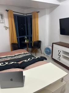 um quarto com uma cama com um computador portátil em Grand Riviera Suites em Manila