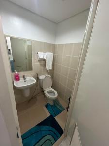 a bathroom with a toilet and a sink at Grand Riviera Suites in Manila