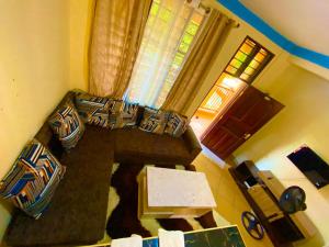 een woonkamer met een bank en een tafel bij Cozy Holiday Homes. in Ukunda