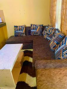 ein Sofa mit Kissen darauf im Zimmer in der Unterkunft Cozy Holiday Homes. in Ukunda