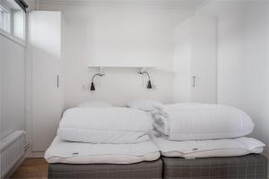 uma pilha de almofadas em cima de uma cama em Kungsberget Åhus C2, Semesterboende & Lägenhet em Järbo