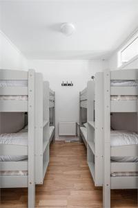 a room with four white bunk beds in it at Kungsberget Åhus C2, Semesterboende & Lägenhet in Järbo