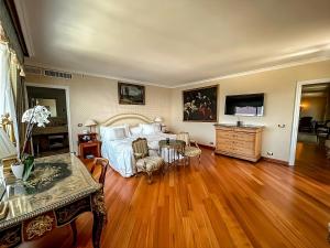 博爾迪蓋拉的住宿－戴爾瑪爾度假及SPA大酒店，一间卧室设有一张大床,铺有木地板