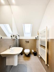 a bathroom with a sink and a toilet with skylights at SI-View Doppelzimmer Zimmer 23 in Siegen