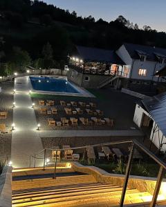 a resort with a swimming pool and a lot of chairs at Pensiunea Mara Băile Botiza in Botiza